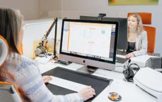 Mitarbeiterin von ImmoGrafik im Büro bei der Kundenberatung am Computerarbeitsplatz.
